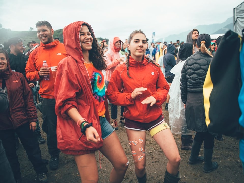 Zwei Frauen tanzen mit roten Regenjacken zu der Musik