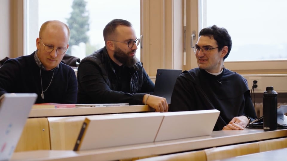 Mönch Meinrad mit zwei Mitstudenten im Vorlesungssaal der Universität Fribourg