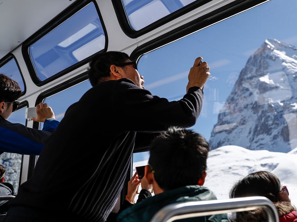 Chinesische Touristen machen Fotos von der Eigernordwand.