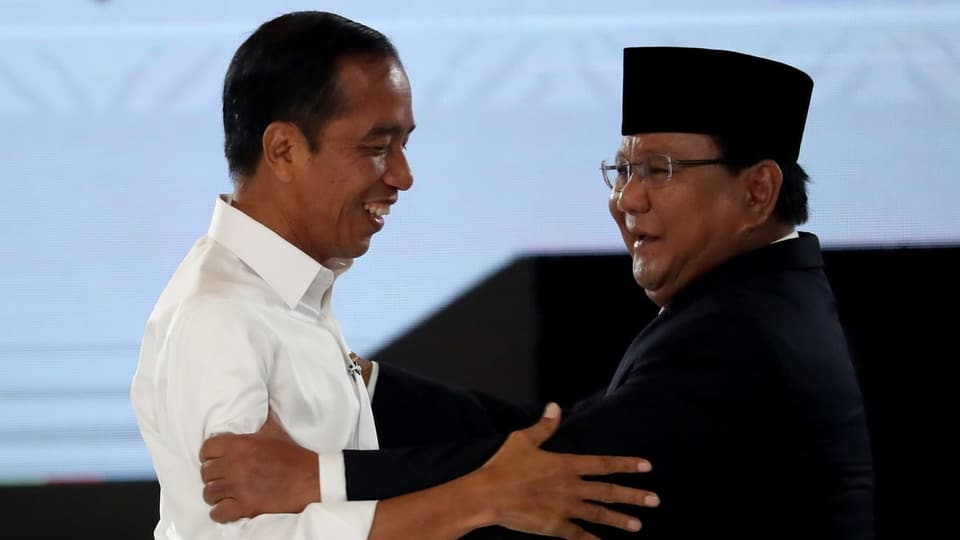 Joko Widodo und Prabowo Subianto halten sich an den Armen fest. 