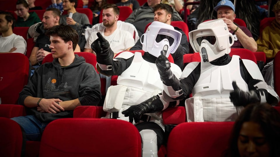 Zuschauer im Kino, darunter zwei Personen in Stormtrooper-Kostümen