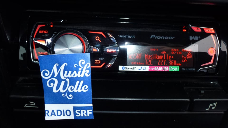 Das Logo von SRF Musikwelle vor dem Display eines DAB-Autoradios.
