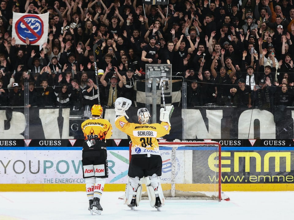 Thurkov, Lugano's top scorer, and goalkeeper Schlegel cheer in front of their fans.