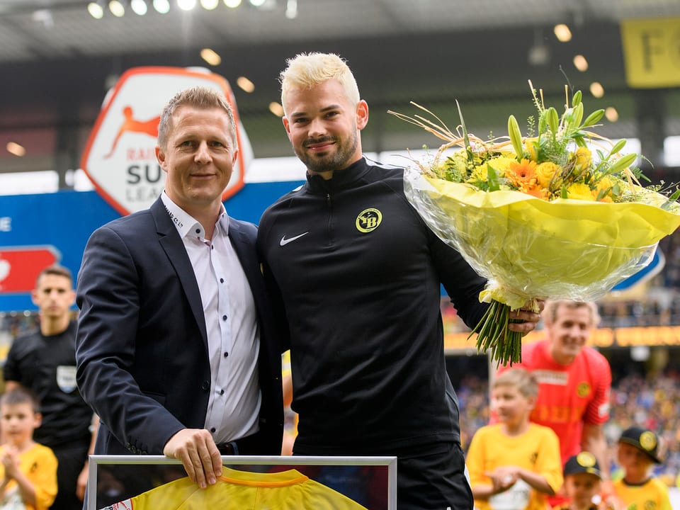 Sportchef Spycher überreicht Bürki einen Blumenstrauss