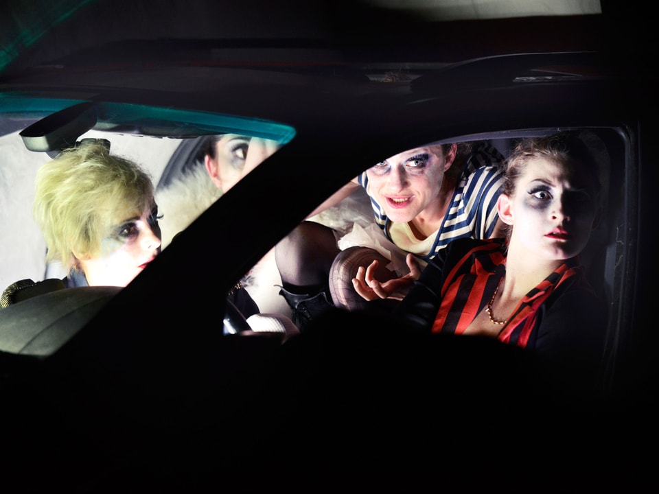 Vier Schauspielerinnen sitzen in einem Auto, rundherum ist es dunkel.