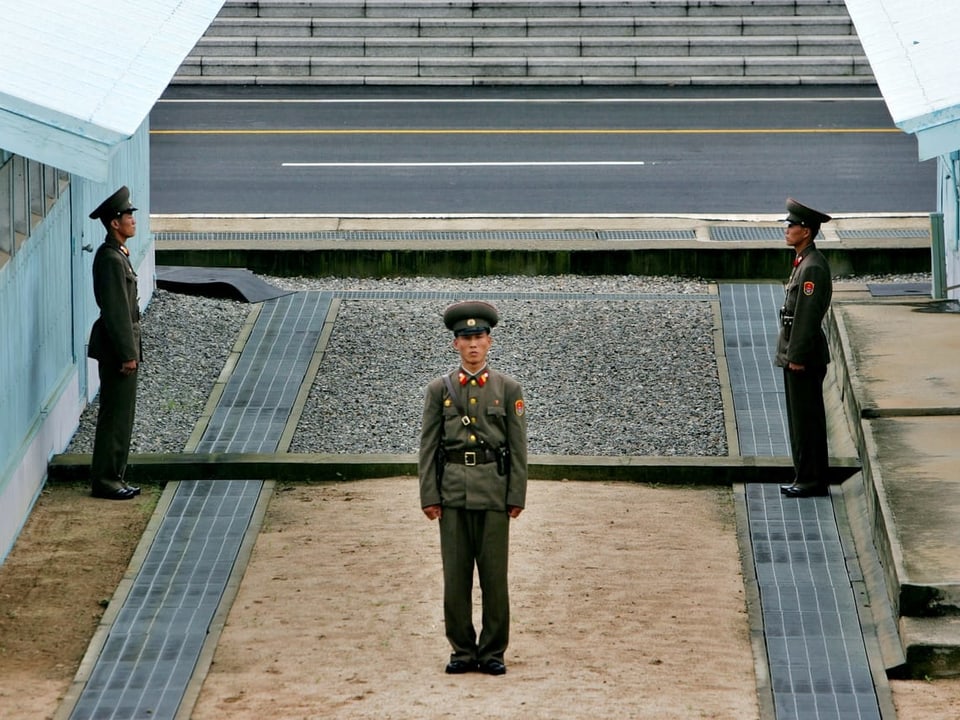 Drei schmächtige, nordkoreanische Soldaten an der Demarkationslinie