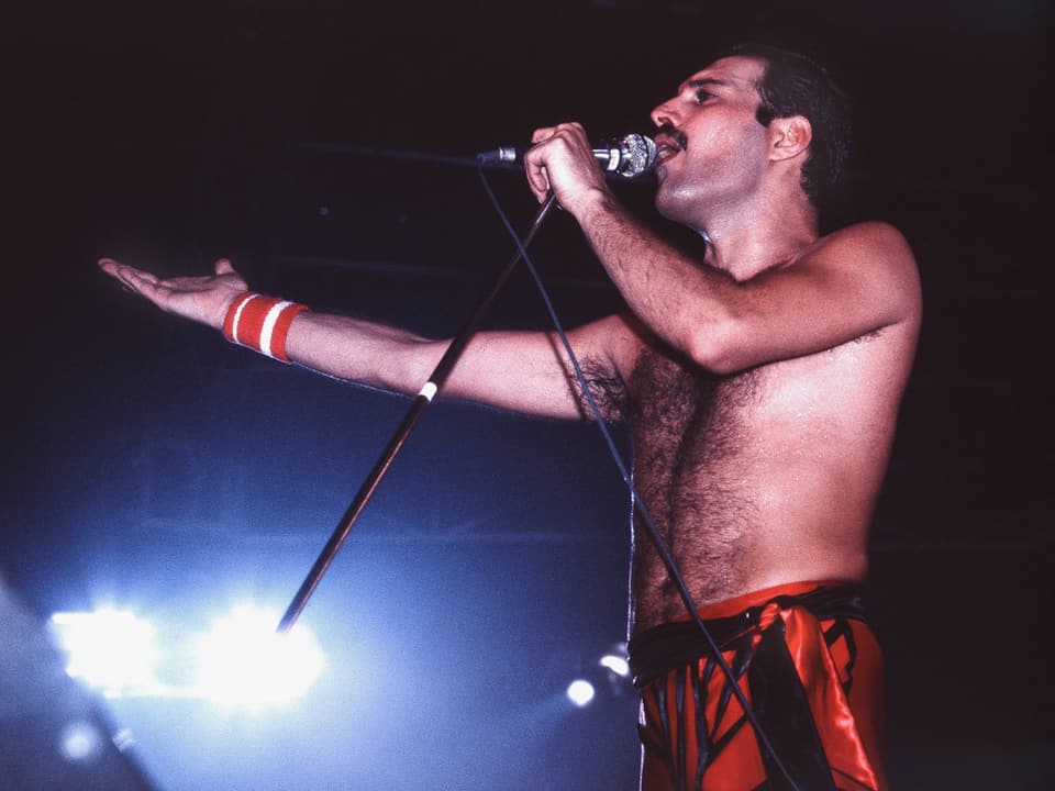 Freddie Mercury singt auf der Bühne.