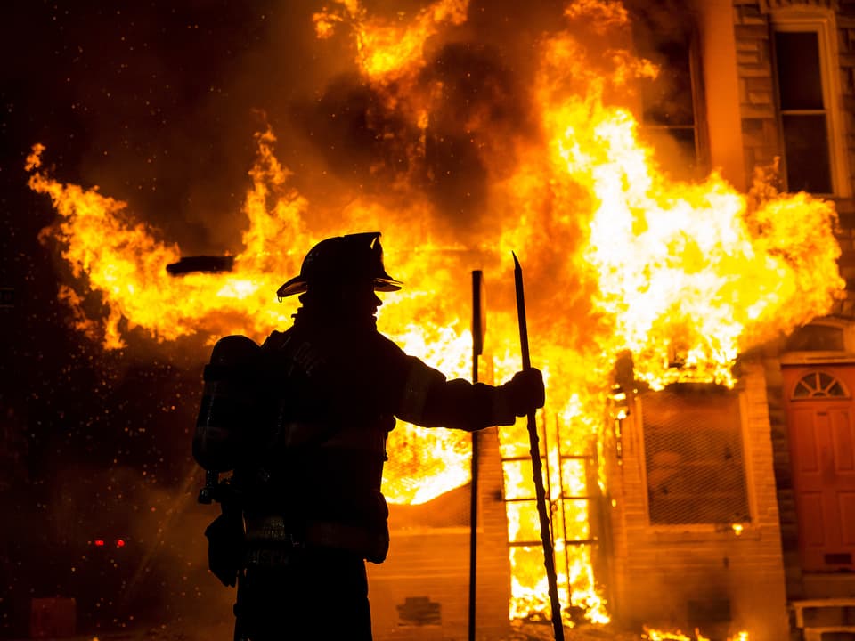 Feuerwehrmann vor brennendem Gebäude in Baltimore. 