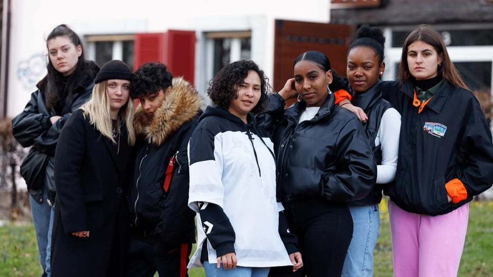 Eine Gruppe junger Frauen steht im Garten vor einem Haus.