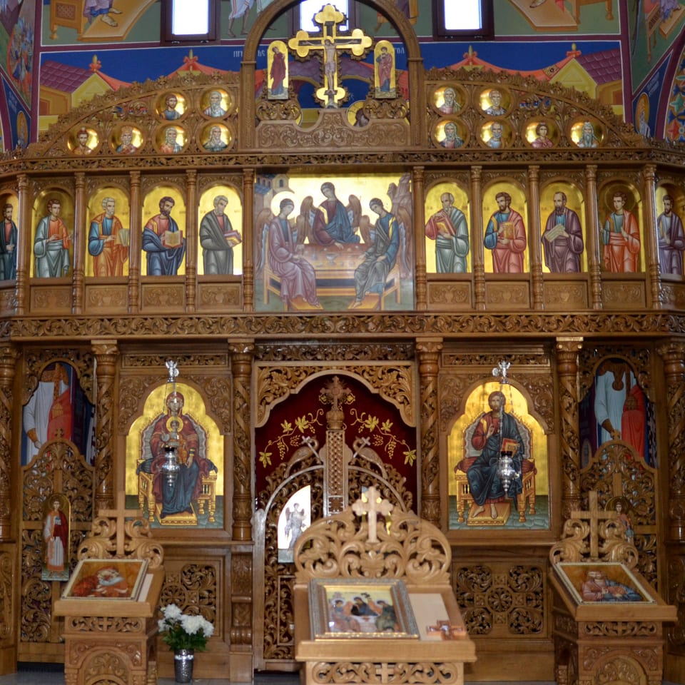 Die Trennwand zum Altarraum ist bemalt und mit Schnitzereien verziert. 