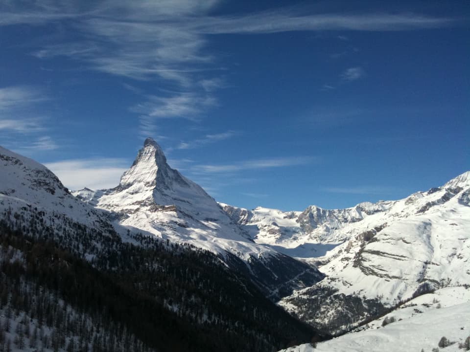 Matterhorn schneebedeckt vor blauem Himmel.