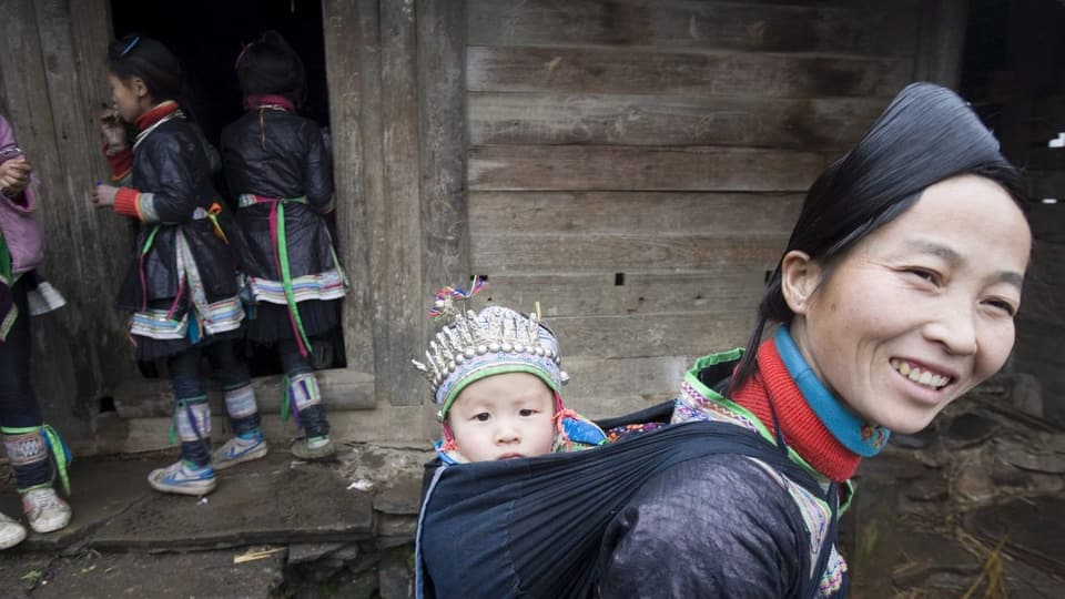 Eine Frau und Kinder der Dong, in traditioneller Kleidung