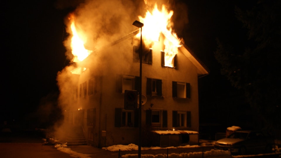 Flammen schlagen aus den Fenstern des Dachgeschosses.