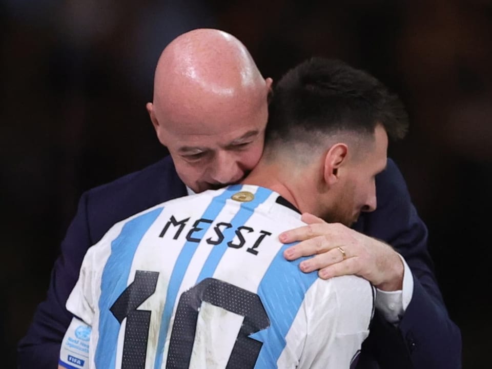 Gianni Infantino umarmt Lionel Messi.