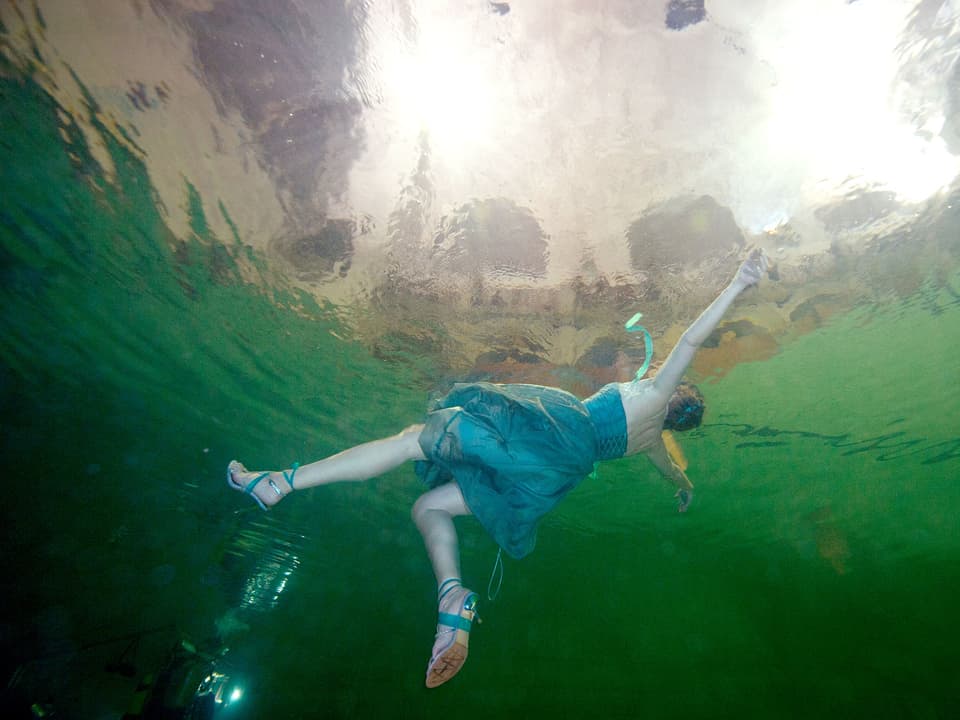 Frau in Abendkleid unter Wasser