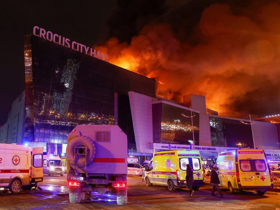 Rescue vehicles in front of burning building.