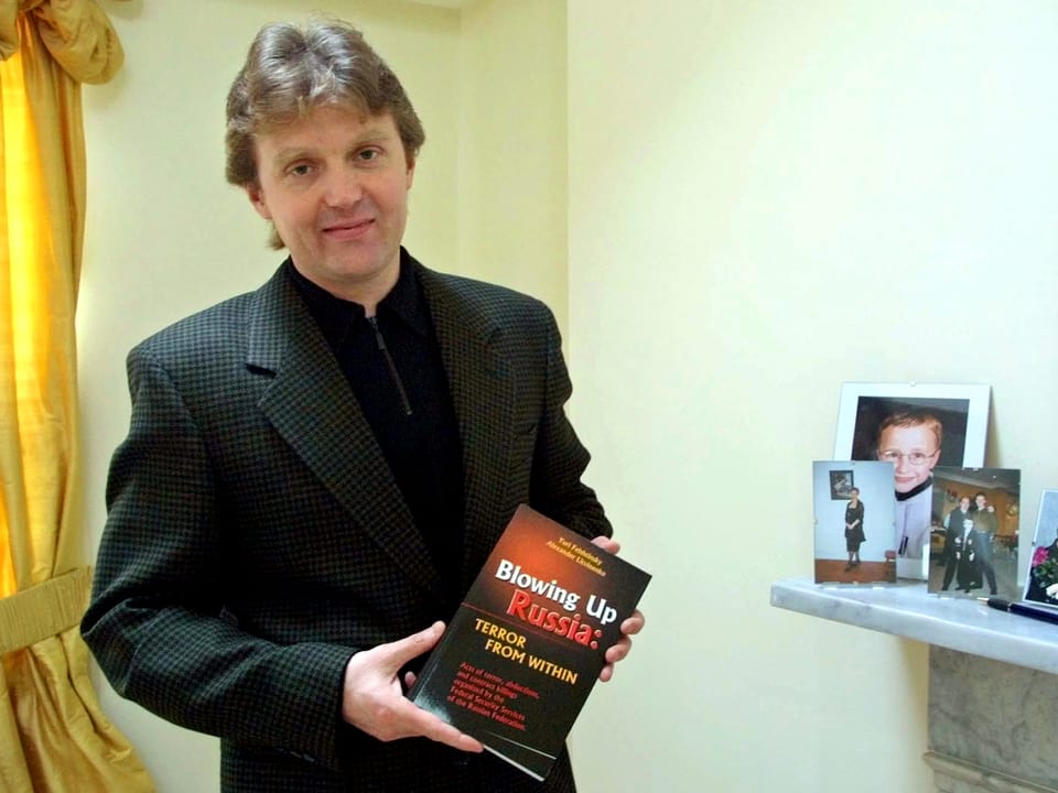Litwinenko hält ein Buch in seinen Händen.
