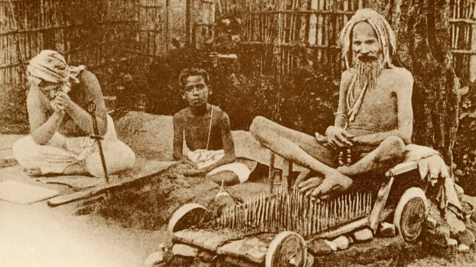 Eine historische Aufnahme eines Inders, der auf einem sogenannten Nadelkissen sitzt.