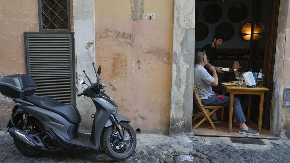 Ein Kellner bedient Kunden in einem Restaurant in der Innenstadt von Rom.