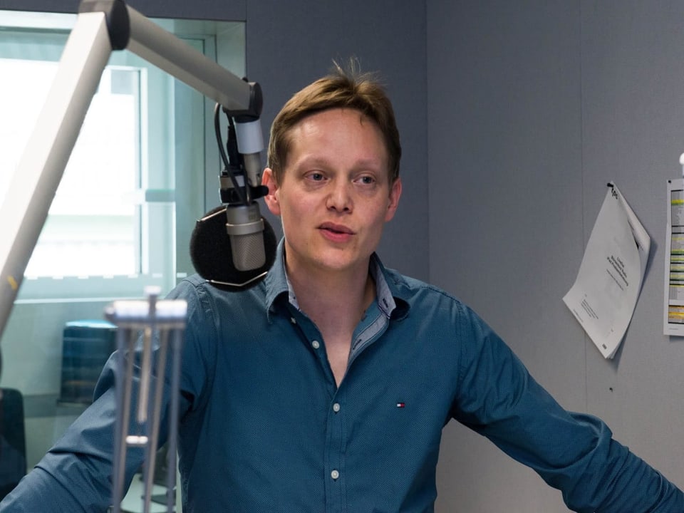 Das Bild zeigt einen Mann in einem Radiostudio.