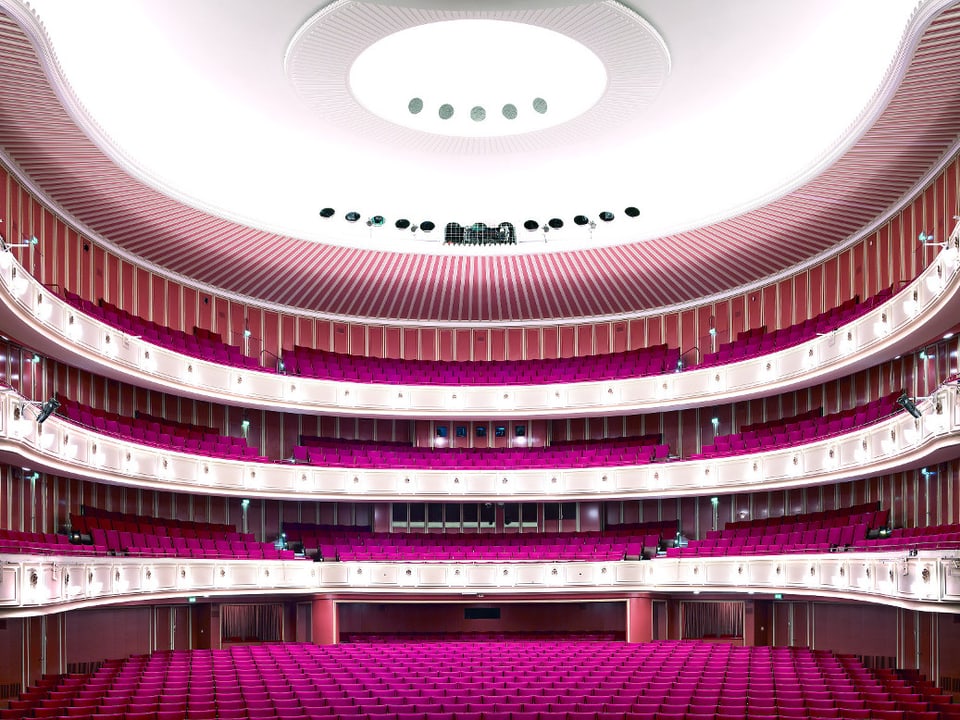 Blick in einen leeren, vierstöckigen Zuschauerraum mit purpurfarbenen Sesseln.