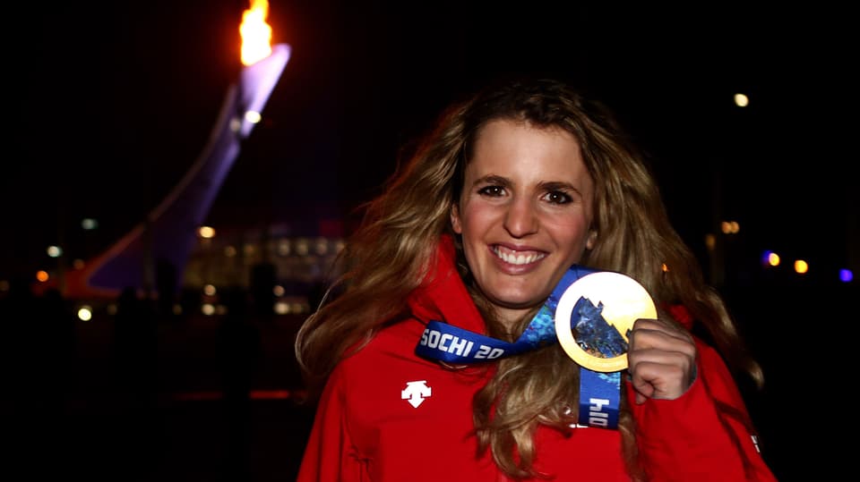 Patrizia Kummer lacht und streckt die Goldmedaille in die Kamera.