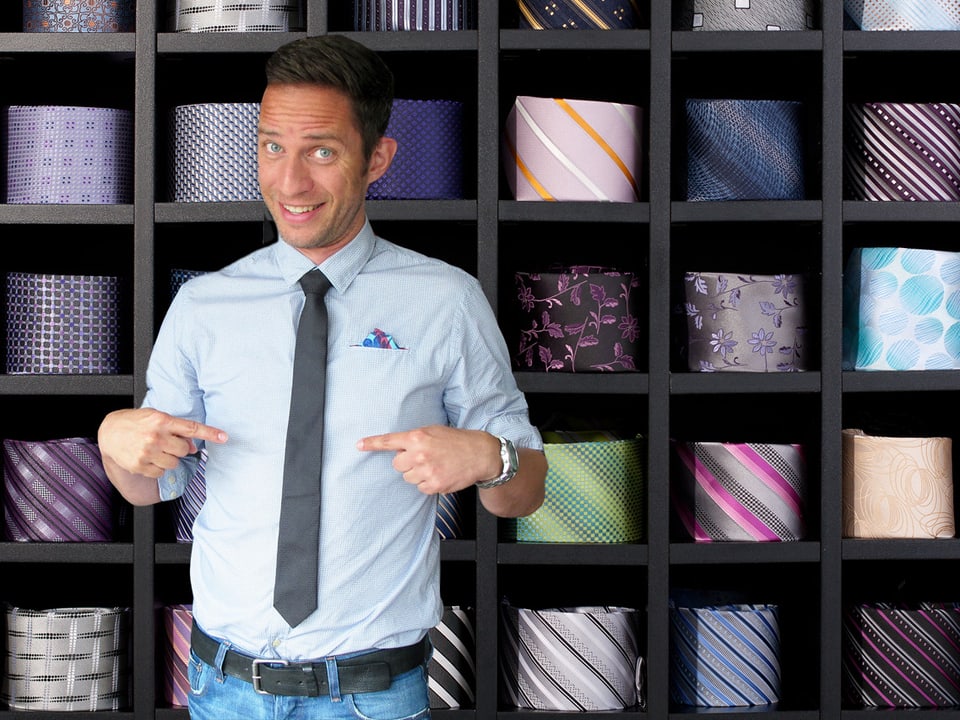 Adrian Küpfer mit Krawatte vor einem Regal mit vielen Krawatten (Bildmontage).