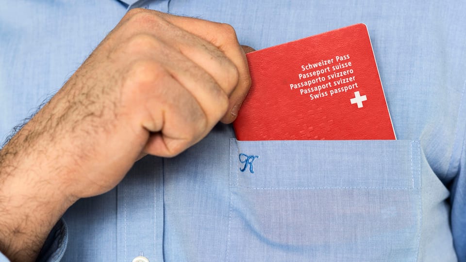 Mann steckt Schweizer Pass in Hemdtasche.