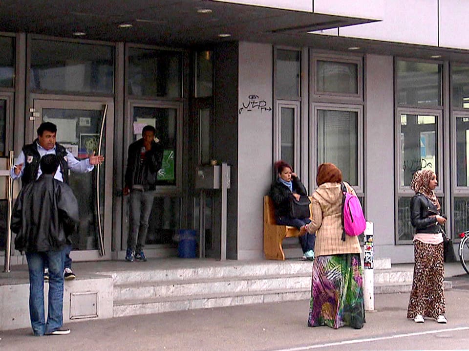 Ein paar Menschen stehen vor der Autonomen Schule in Zürich.