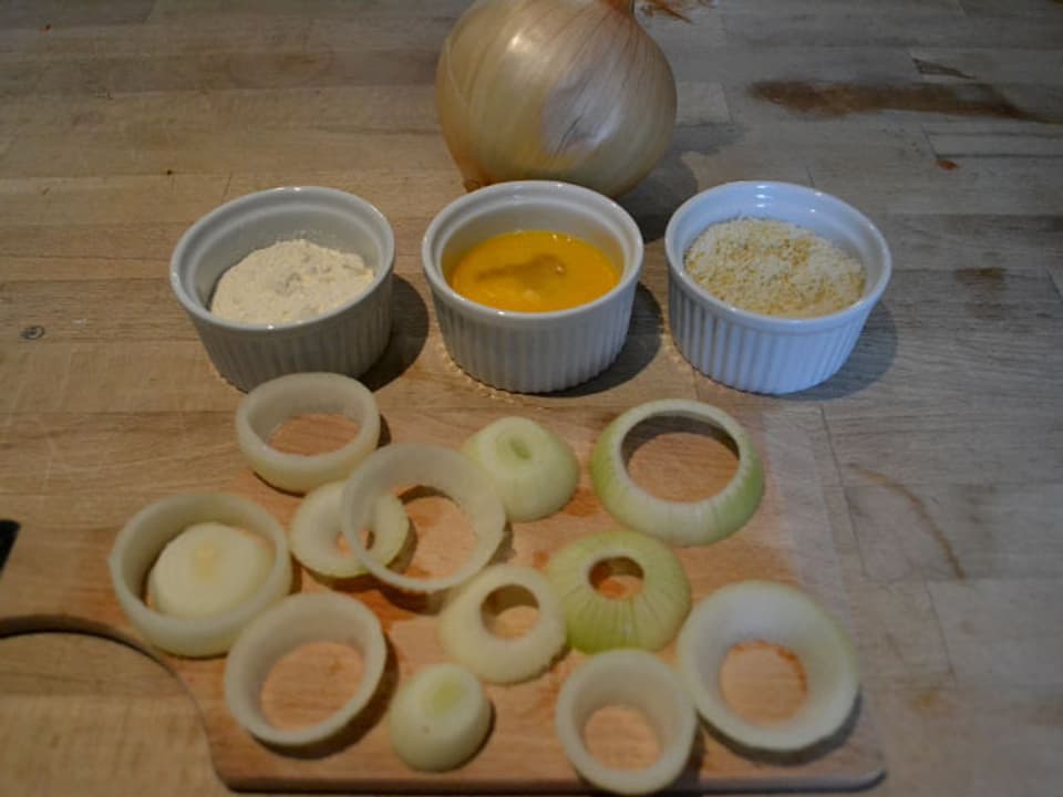 Zwiebelringe, gefässe mit Mehl, Ei und Parmesan und Paniermehl. 