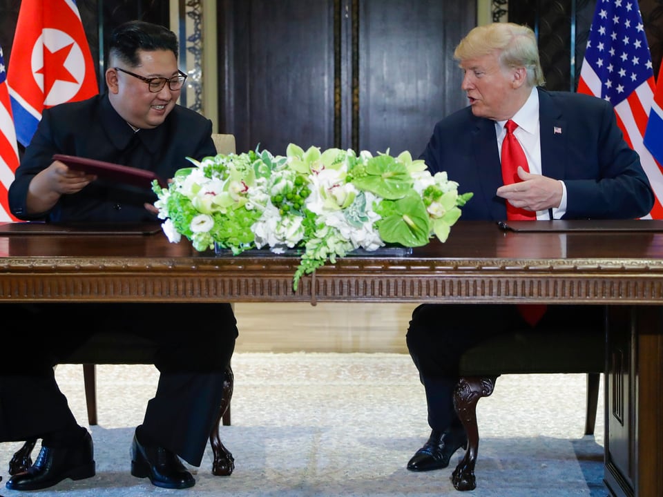 Trump und Kim am Tisch.