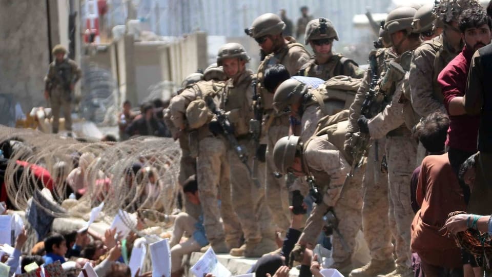 US-Soldaten am Flughafen Kabul, vor ihnen Afghanen, die ausreisen wollen.