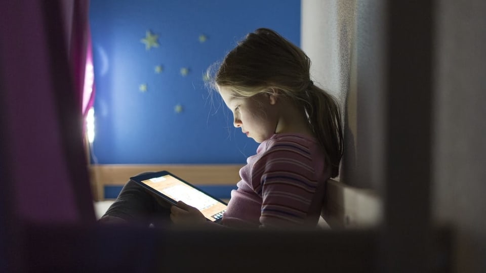 Mädchen surft auf einem Tablet im Internet