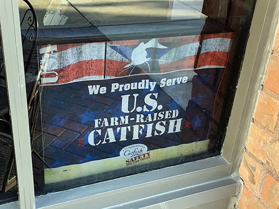 Tafel in einem Fenster mit der Aufschrift: «U.S. farm-raised Catfish» (In US-Farmen gezüchteter Katzenwels)