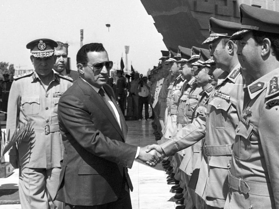 Mubarak schüttelt einem Offizier die Hand. (Schwarz-Weiss-Bild)