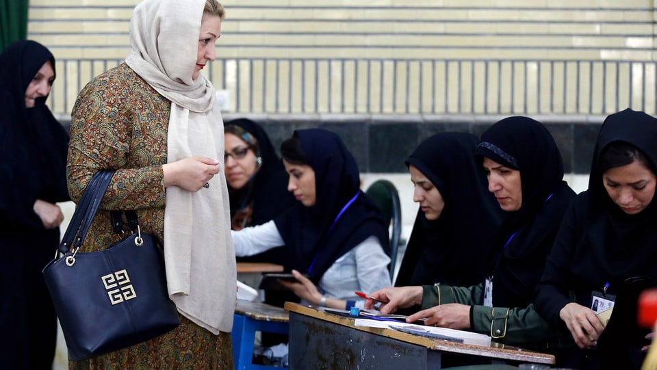 Eine Frau bei der Stimmabgabe in einem iranischen Wahlbüro.