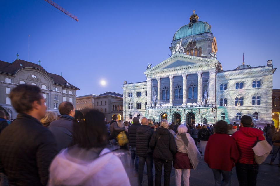 Zuschauer verfolgen das Lichtspektakel «Rendez-vous Bundesplatz» in Bern.
