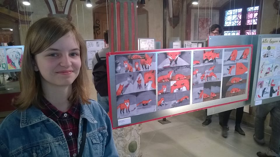 junge Frau vor einer Bildergeschichte mit roten Füchsen