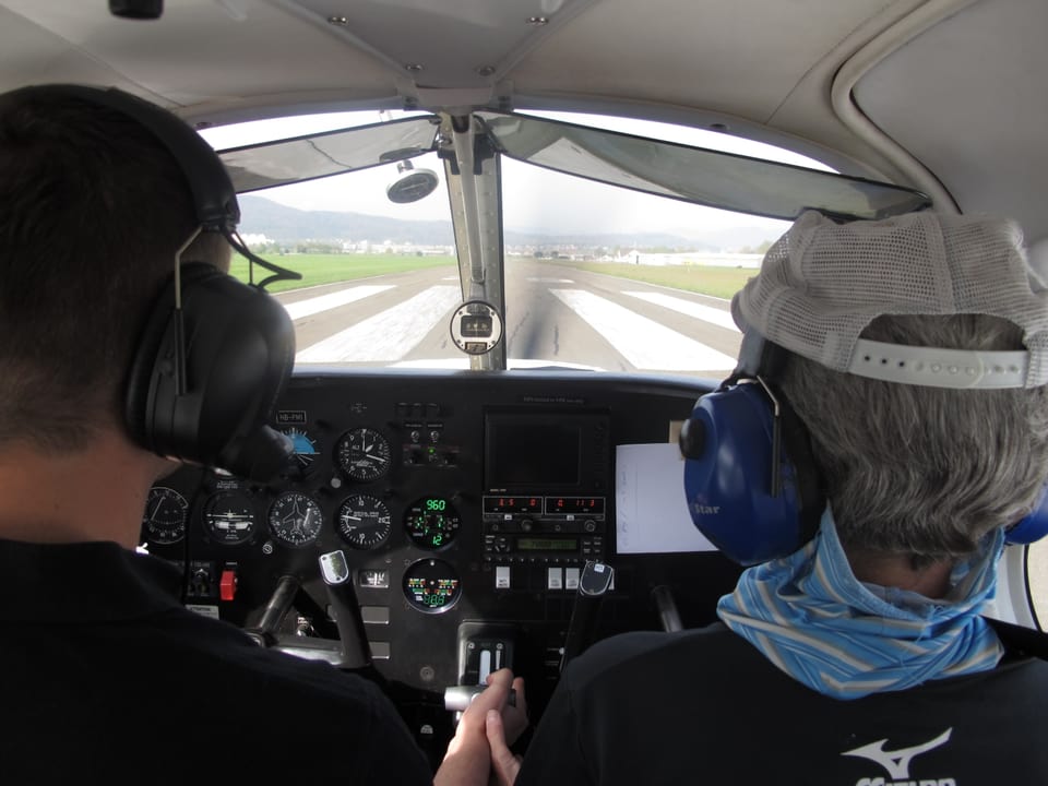 Blick aus der hinteren Reihe auf das Cockpit und die Landepiste.