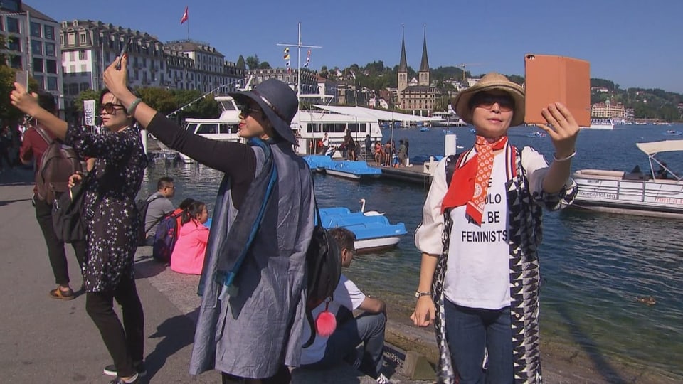 Asiatische Touristinnen machen Selfies am Luzerner Quai.