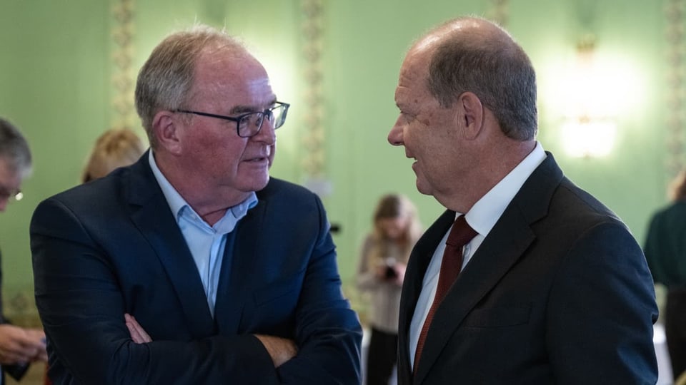Zwei Männer stehen sich gegenüber und reden miteinander.