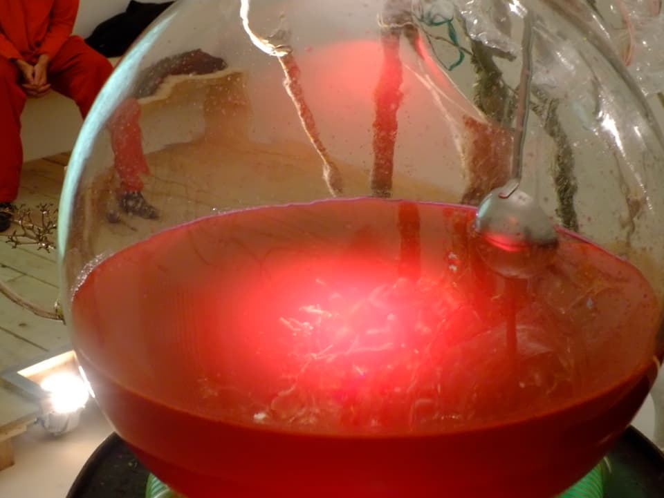 Ein mit rot eingefärbtem Kunstdünger gefülltes Glas.