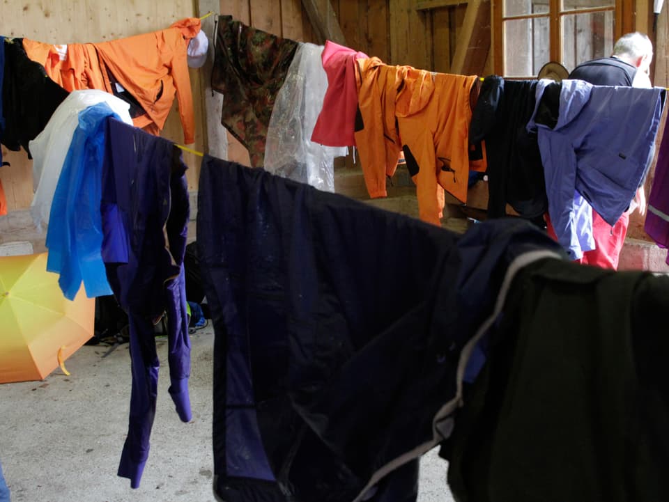 Wäscheleine mit nassen Kleidern behängt.