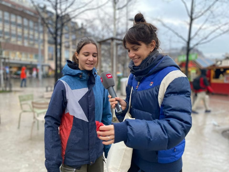 Zoe und Dania stehen auf dem Sechseläutenplatz. Dania hält einen Hundekot-Sack in der Hand.