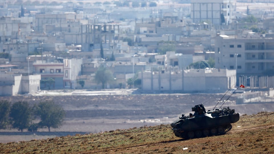 Panzer, im Hintergrund die Stadt Kobane
