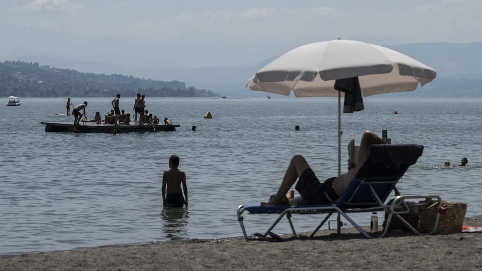 Menschen geniessen am Freitag das Sommerwetter im Strandbad Mythenquai im Zürichsee.