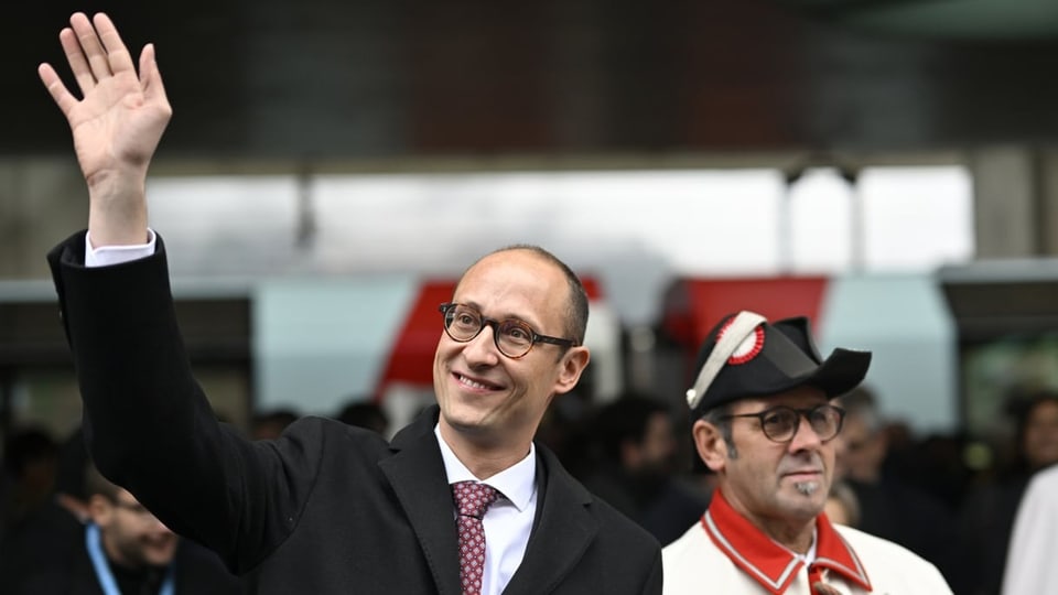 Martin Candinas, begleitet von einem Bundesweibel, winkt mit der Hand