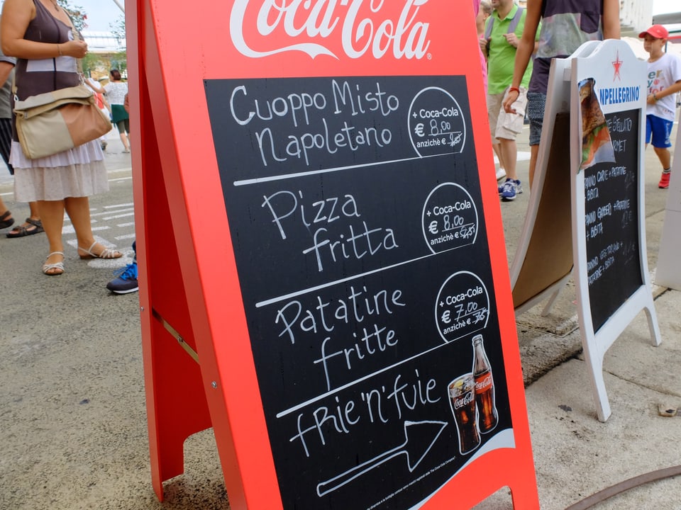 Menütafel mit Kalorienbomben wie Pizza mit Pommes Frites und Cola.