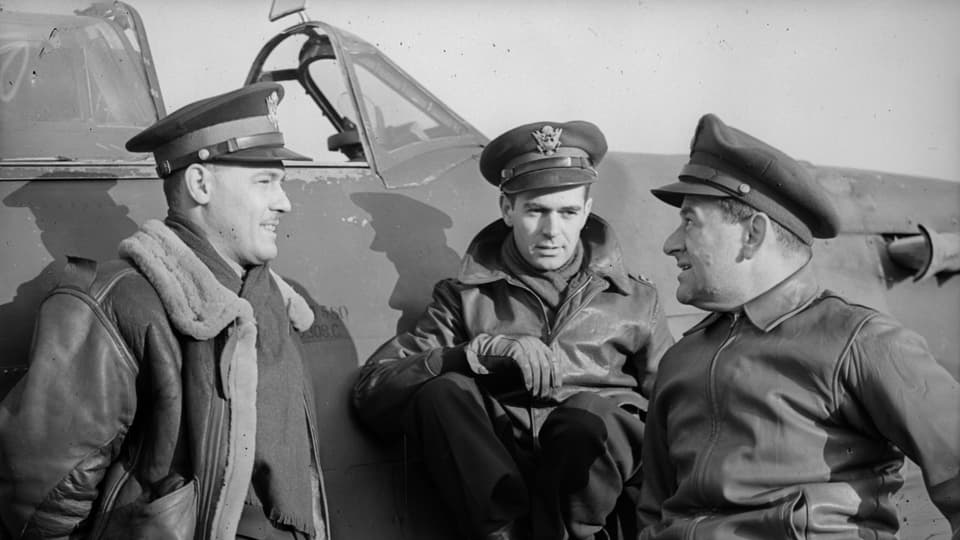 Auf dem Bild sind drei Männer vor einem Flugzeug zu sehen.