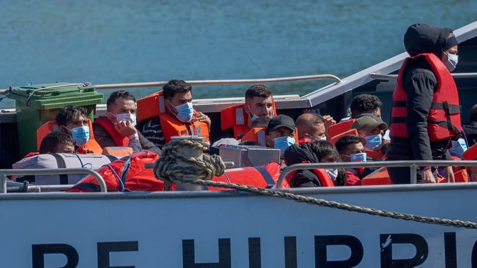 Flüchtlinge sitzen in einem britischen Boot.